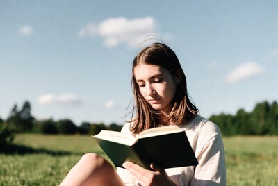 Woman reading book in grass