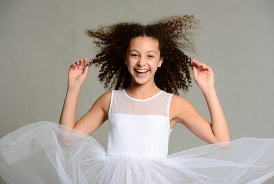 Girl with curly hair in white tutu dress