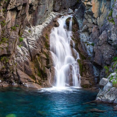 Waterfall cascading into turquoise pool