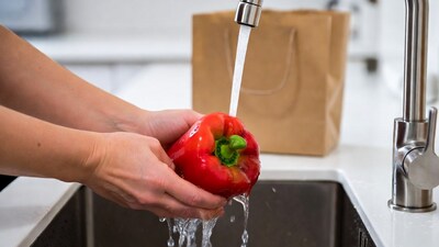 Woman washing red bell pepper