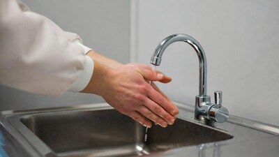 Woman washing hands under faucet