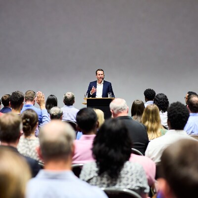 Man speaking at podium to audience