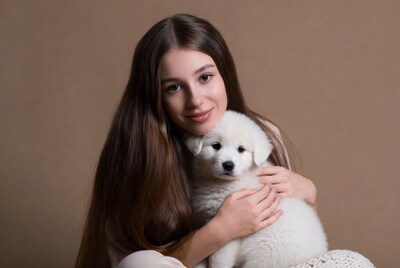 Girl holding white puppy