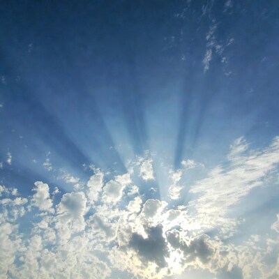 Sun rays through fluffy clouds