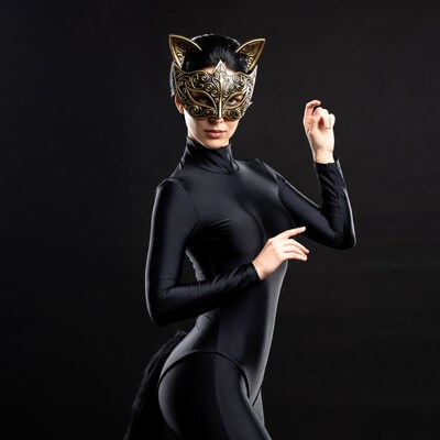 Woman in black catsuit with gold cat mask