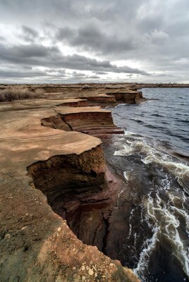 Red layered cliffs by lake