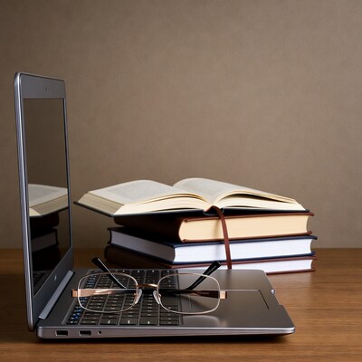 Laptop with glasses and books