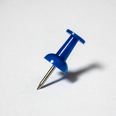 Blue push pin on white background