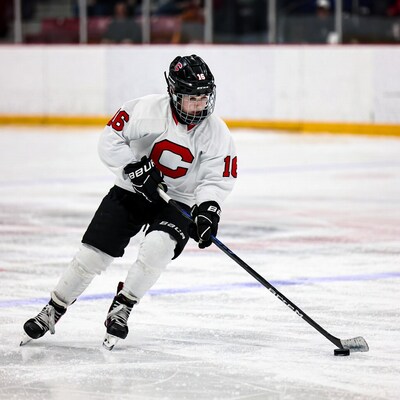 Boy playing hockey on ice rink