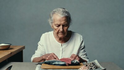 Elderly woman filleting fish
