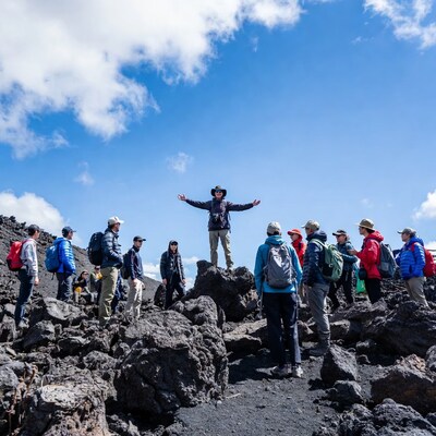 Man leading hikers on volcanic rocks