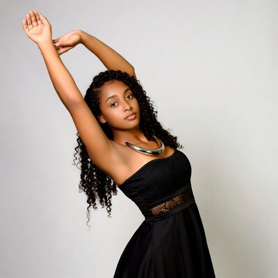 Black woman stretching arms in black dress