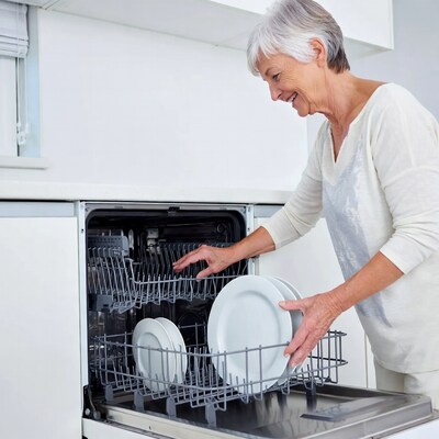 Elderly woman unloading dishwasher