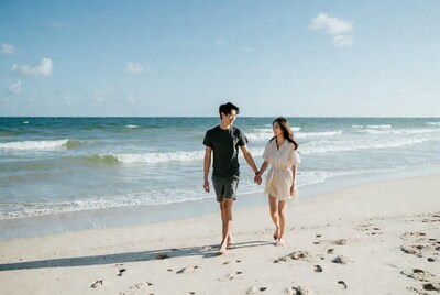 Asian couple holding hands on beach