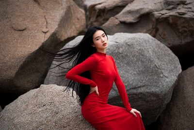 Asian woman in red dress on rocks