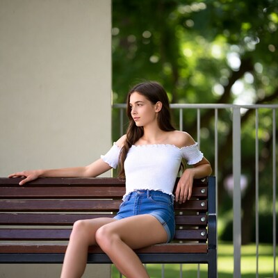 Teen girl sitting on park bench