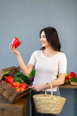 Woman holding red bell pepper at market
