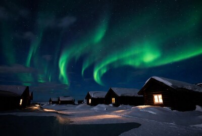 Northern Lights over snowy cabins