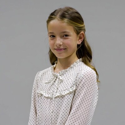 Girl in polka dot blouse smiling