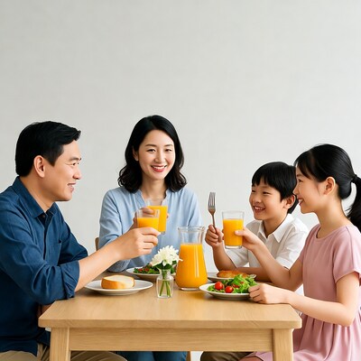 Asian family drinking orange juice at breakfast