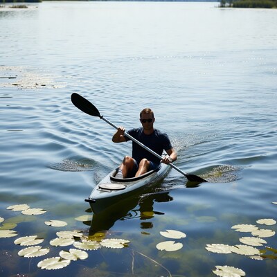 Man kayaking through water lilies