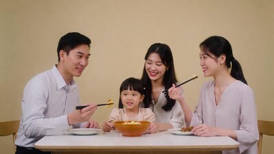 Asian family eating noodles with chopsticks