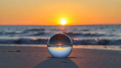 Glass sphere capturing sunset over beach