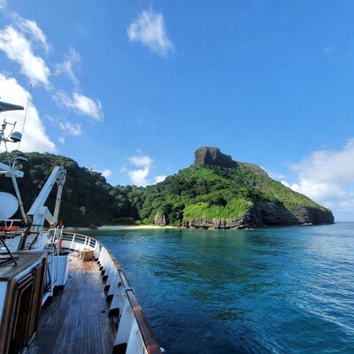 Yacht near tropical island cliff