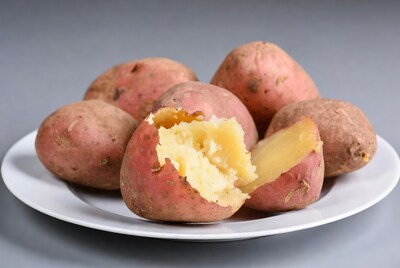Split baked potatoes on white plate