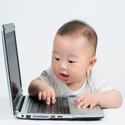 Asian baby typing on laptop