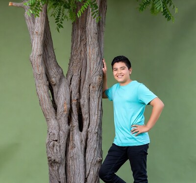 Latino boy leaning against tree