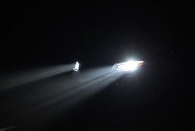 Car headlights beaming in dark night