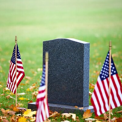 Headstone with American Flags in Grass