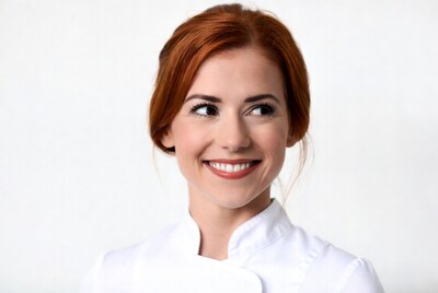 Smiling redhead woman in chef uniform