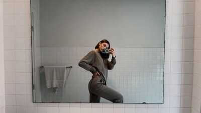 Woman taking selfie in bathroom mirror