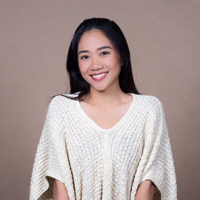 Asian woman smiling in white knit sweater