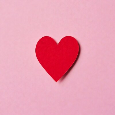 Red paper heart on pink background