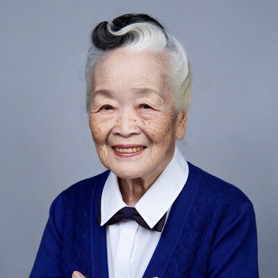 Elderly Asian woman smiling in blue cardigan