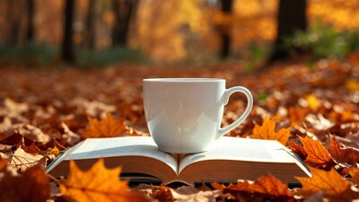 White Cup on Open Book with Autumn Leaves