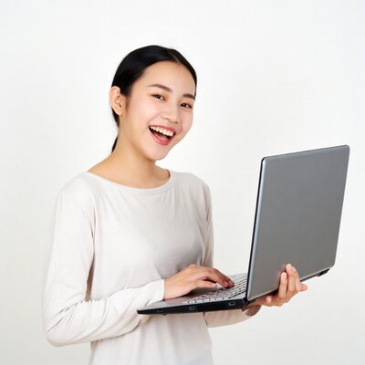 Asian woman smiling typing laptop