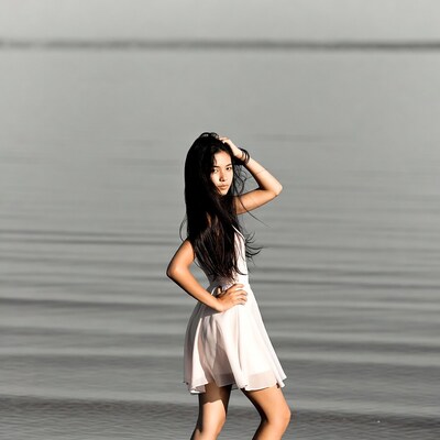 Young Asian woman in white dress by water