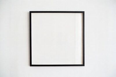 Empty black picture frame on white wall