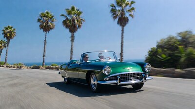 Green vintage convertible driving on road