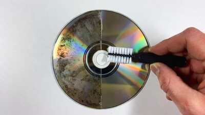 Hand cleaning dirty DVD with brush