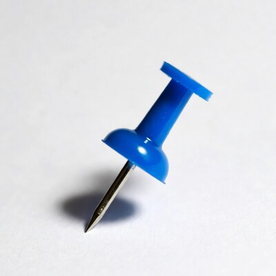 Blue push pin on white background