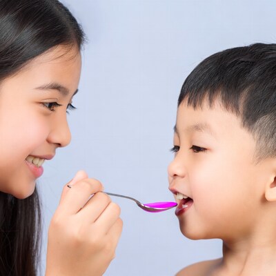 Girl feeding boy with spoon