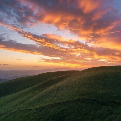 Sunset over rolling green hills