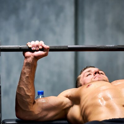 Muscular man bench pressing barbell