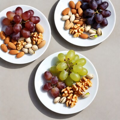 Three plates of mixed nuts and grapes