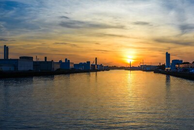 Industrial sunset over calm water